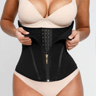 Person wearing a black waist trainer over a beige bra and panties on a white background